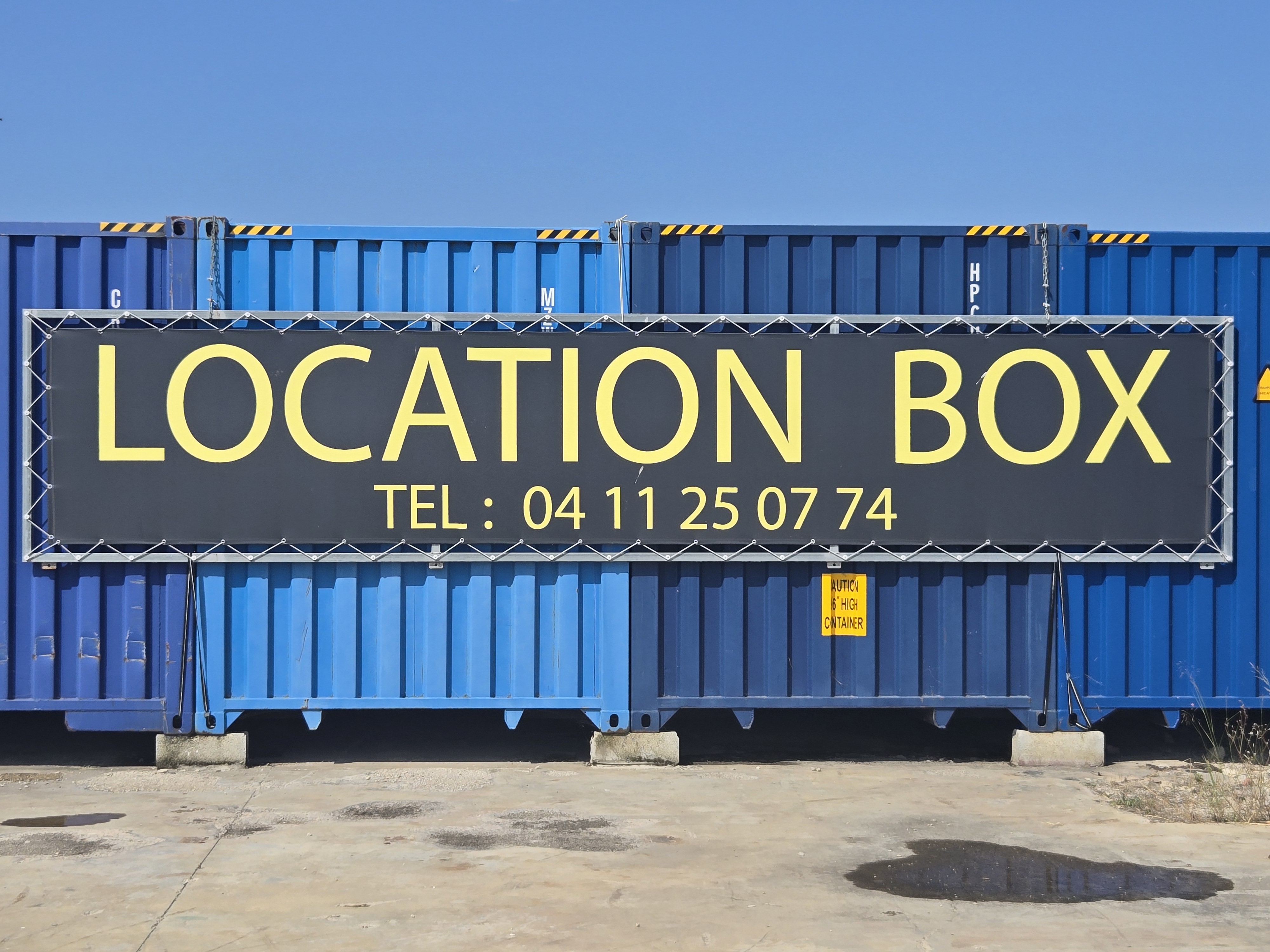 Entrée BOX 30 – enseigne entre deux palmiers, Aigues-Mortes